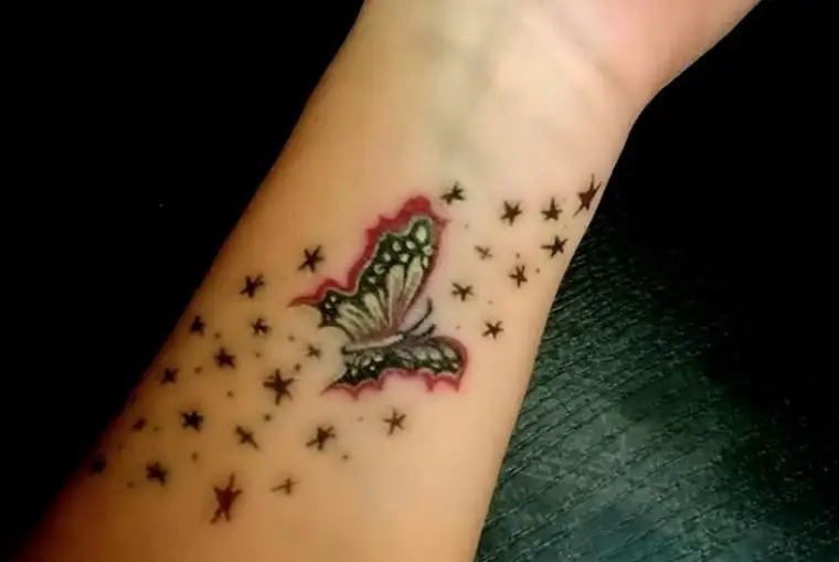 Red black and yellow colored butterfly with stars tattoo on wrist.