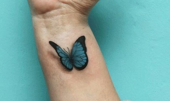 Blue butterfly tattoo on wrist.
