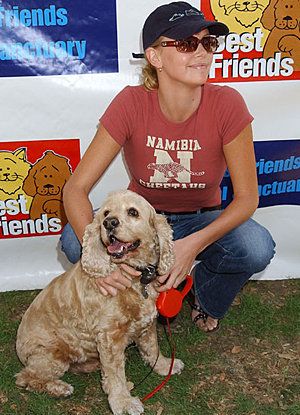 Charlize Theron with her Cocker Spaniel sitting on the grass