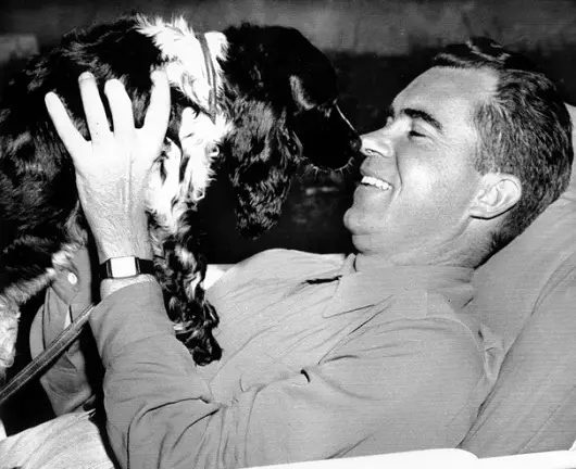 Richard Nixon with his Cocker Spaniel smelling his nose