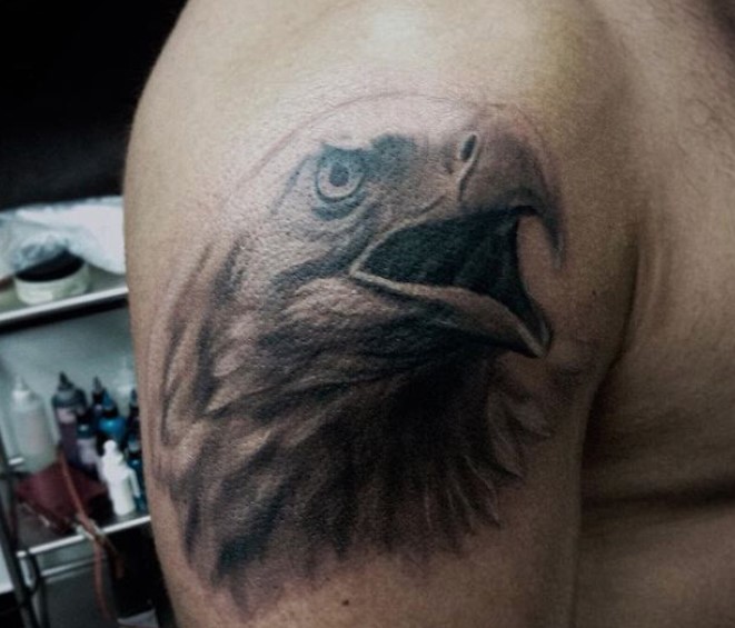 head of an Eagle with its beak open tattoo on the shoulder