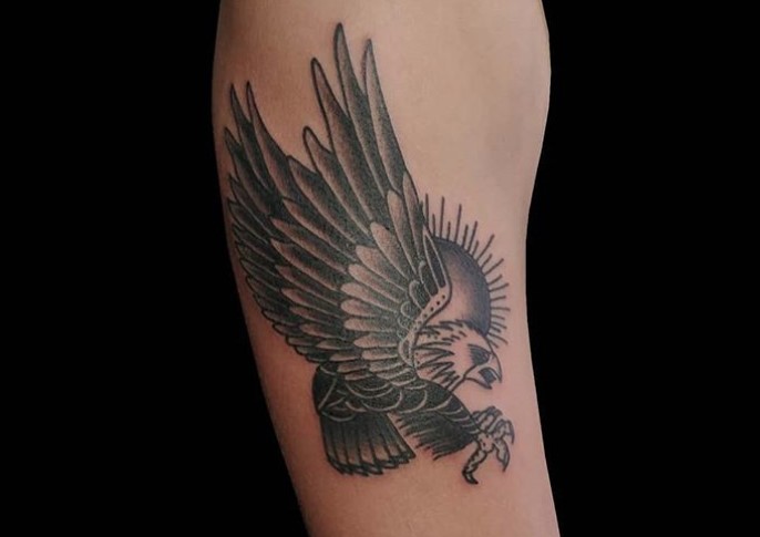 flying Eagle with a sun peeking behind it tattoo