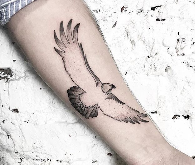 minimalist flying eagle tattoo on the lef