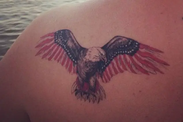black Eagle with white dots and red feathers on its wings tattoo on the back
