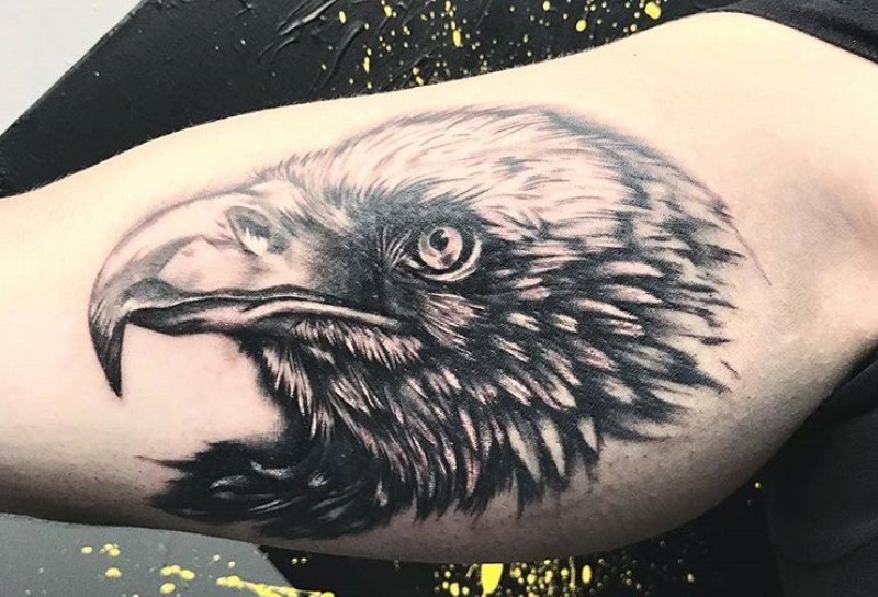 black and gray head of an Black eagle head tattoo. on the biceps