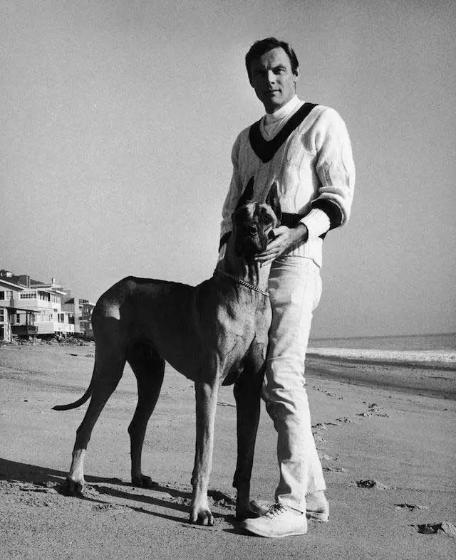 Adam West standing by the seashore next to his Great Dane