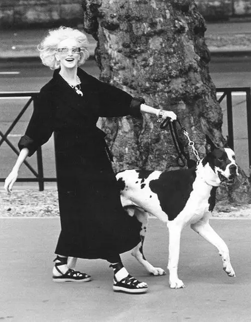black and white photo of Carmen Dell’Orefice walking happily in the street with her Great Dane