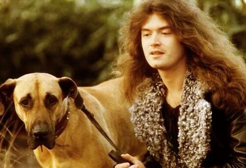 Glenn Hughes sitting on the grass next to his Great Dane