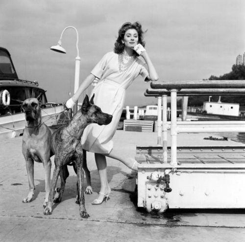 Suzy Parker standing at the port with her two Great Danes