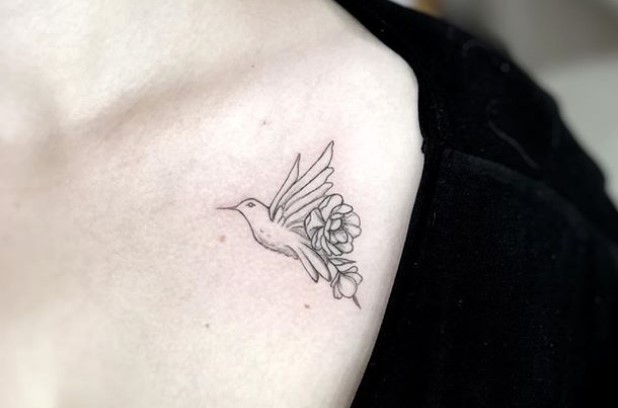 minimalist hummingbird with flowers on its tails tattoo on shoulders