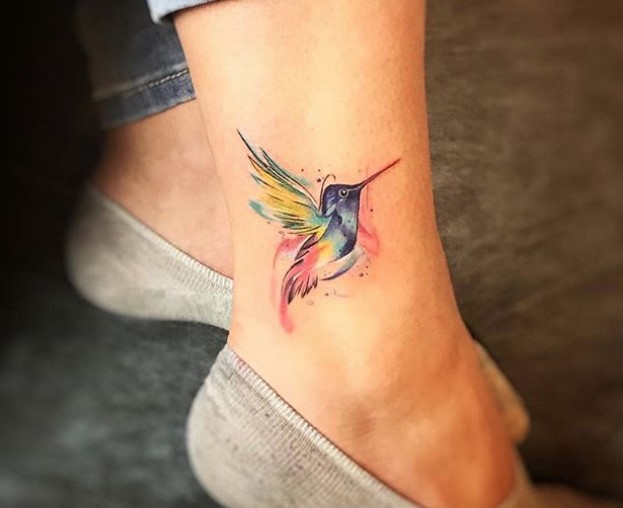 watercolor hummingbird tattoo on girl's ankles