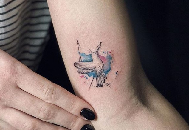 small hummingbird watercolor tattoo on outer arm