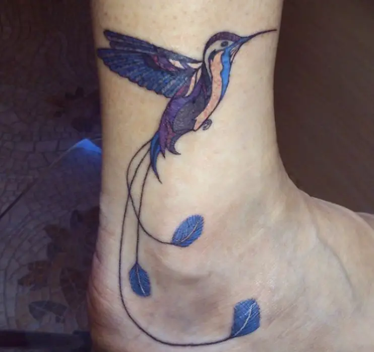 blue, violet, red and cream colored hummingbird tattoo in ankle