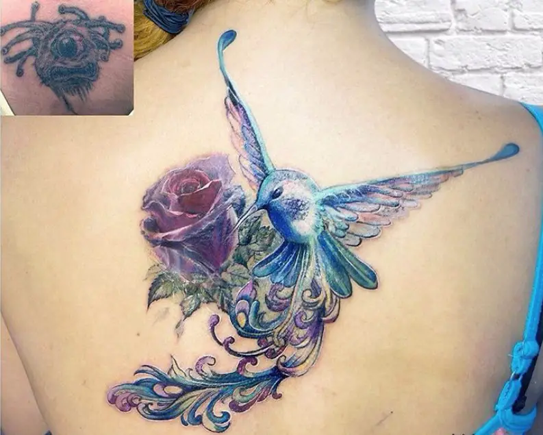 Artistic hummingbird on a rose tattoo on the back