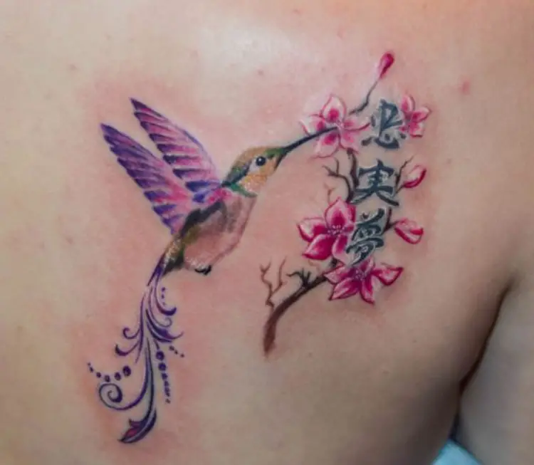 colorful hummingbird with tribal design on its tail tattoo on the back