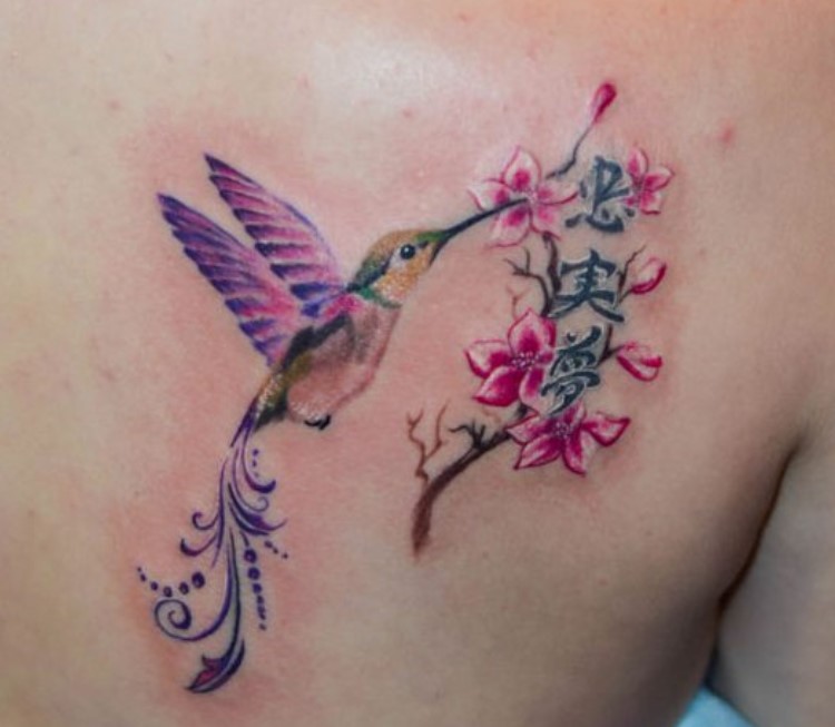 colorful hummingbird with tribal design on its tail tattoo on the back