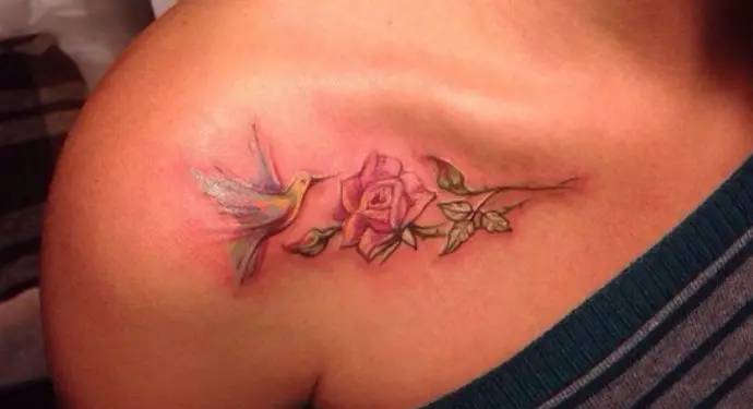 pastel colored hummingbird feeding on rose tattoo on shoulder