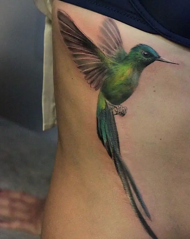 3D green hummingbird tattoo on the side ribs of the body