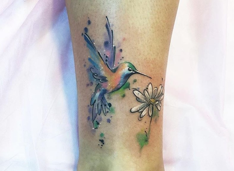 hummingbird on a white flower watercolor tattoo on leg