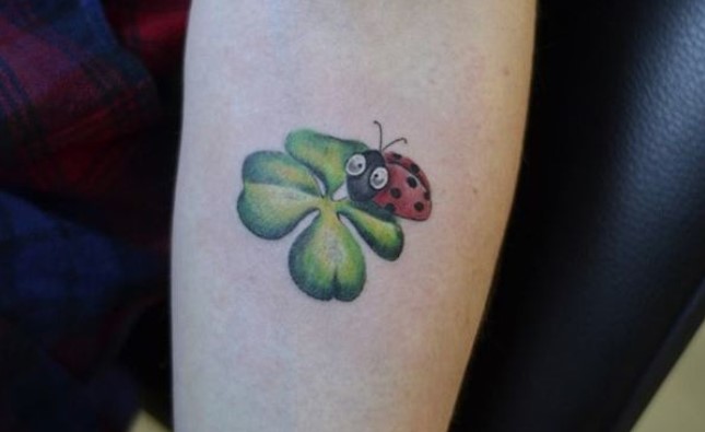 Ladybug with big eyes on a clover Tattoo on the forearm