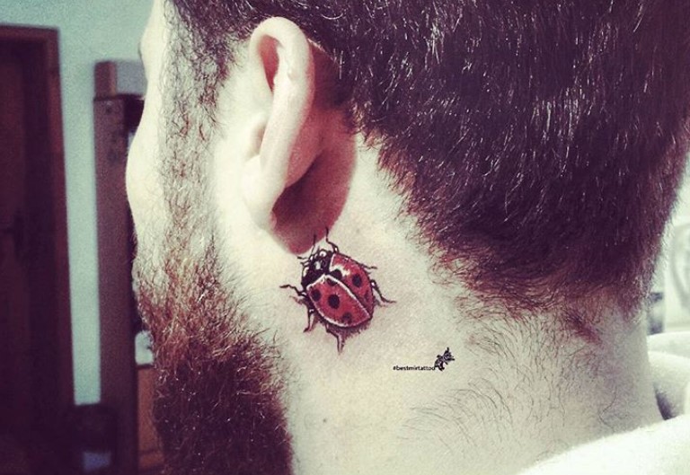 3D Ladybug tattoo behind ear.