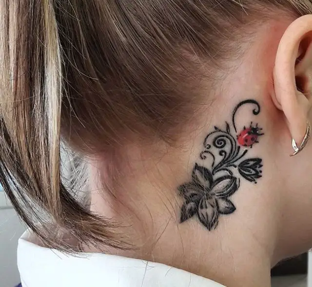 Ladybug and flower tattoo behind the ear