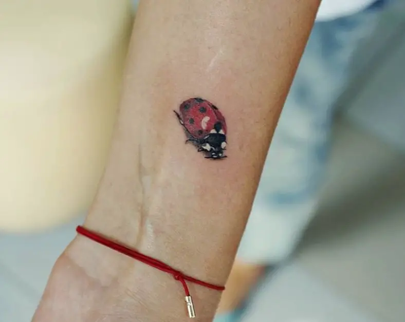 Small realistic Ladybug Tattoo on the wrist
