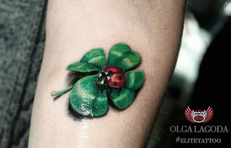 realistic Ladybug on a clover Tattoo on the forearm