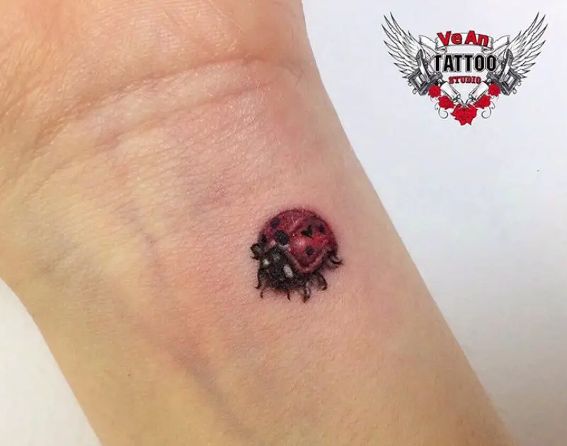 small 3D ladybug tattoo on wrist.