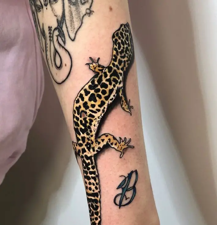 Lizard with leopard print tattoo on the forearm