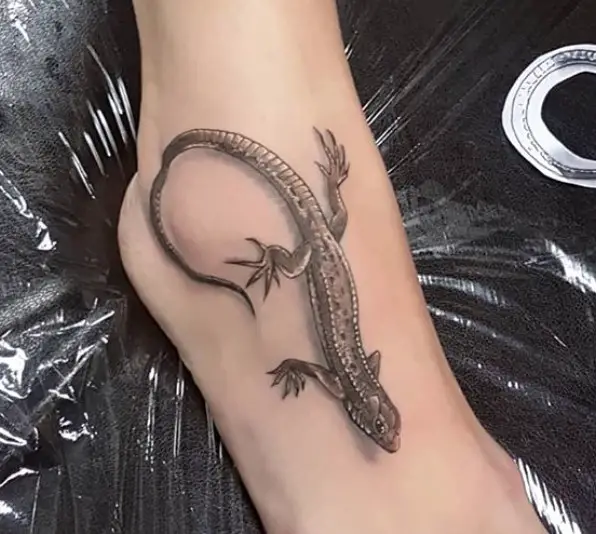 realistic black and gray Lizard Tattoo on foot.
