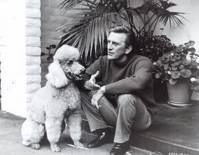 Kirk Douglas sitting in the front porch with his poodle sitting in front of him
