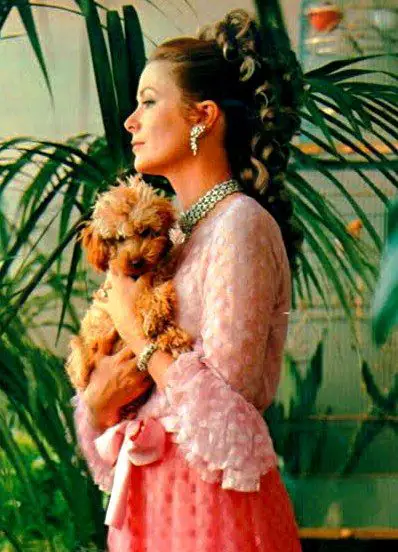 Princess Grace Kelly standing while holding her poodle