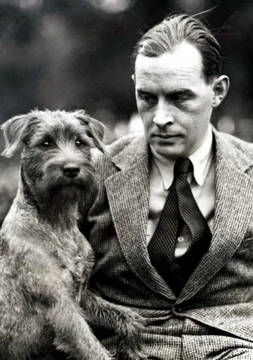 Erich Maria Remarque staring at his Schnauzer who is sitting next to him