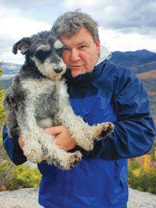 Tom Ryan carrying his Tom Ryan with the view of the mountain in the background