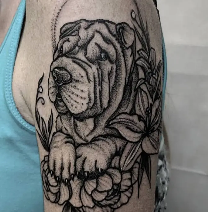 A black and gray Shar-Pei with flowers tattoo on the shoulder