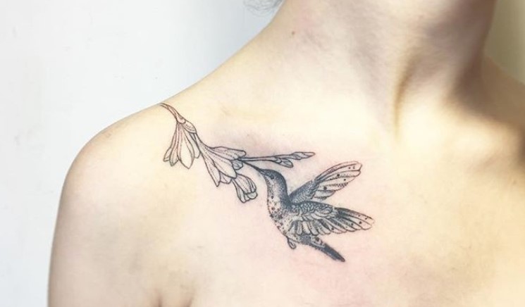 Small Hummingbird feeding from a flower Tattoo on the chest