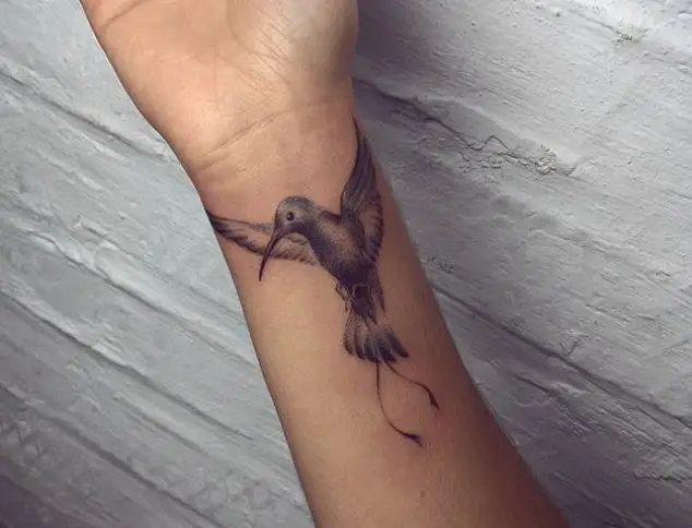 Small Hummingbird with its wings spread Tattoo on the wrist