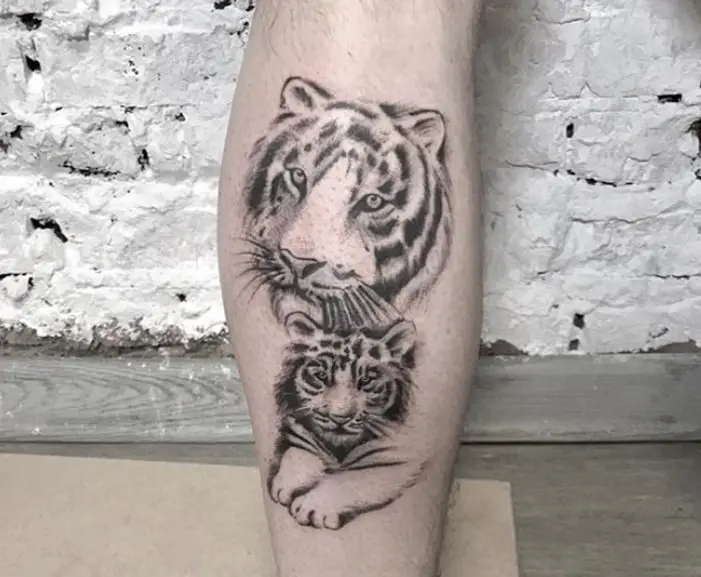 A black and gray 3D face of a Tiger Tattoo on the leg