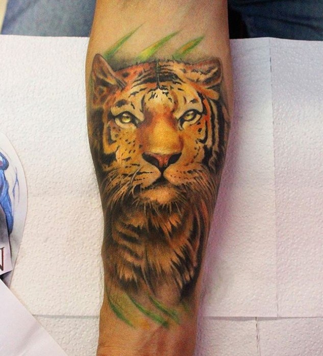 orange face of a Tiger Tattoo on the forearm