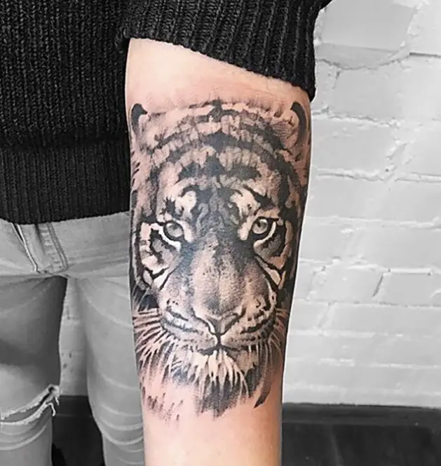 a 3D face of a tiger tattoo on the forearm