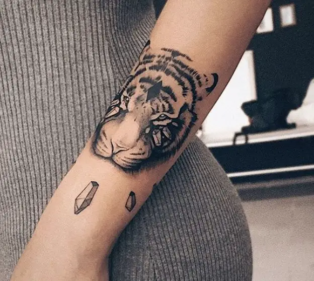 a 3D face of a Tiger Tattoo on the arm of a woman