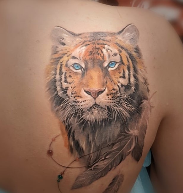 Realistic face of an orange Tiger Tattoo on the back