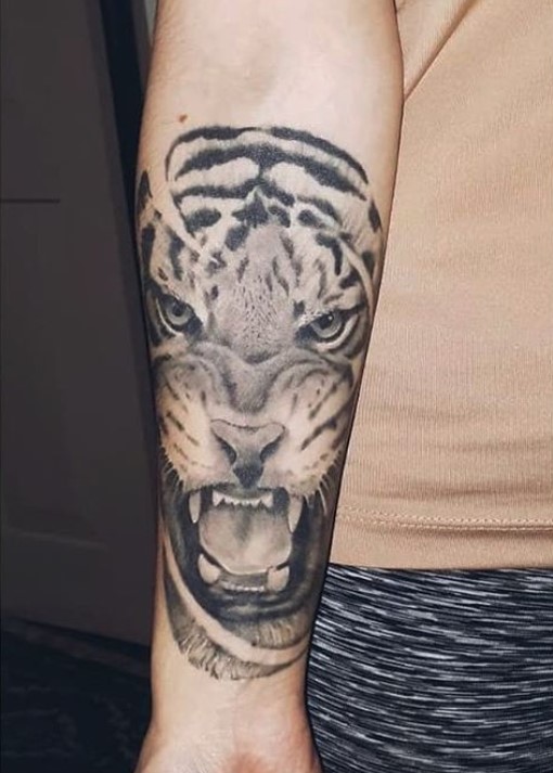 Face of a black and gray Tiger Tattoo on the forearm