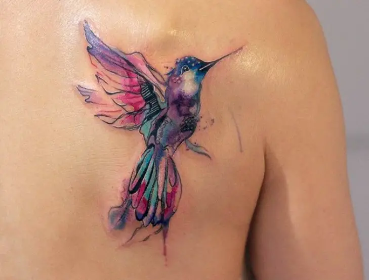 blue, pink, purple watercolor hummingbird tattoo on the shoulder
