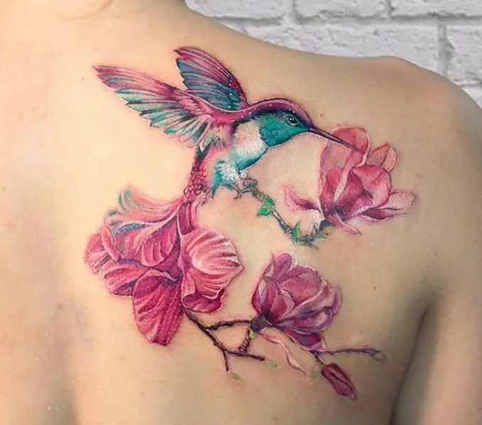 pink and blue colored Hummingbird and pink flowers Watercolor Tattoo on the back