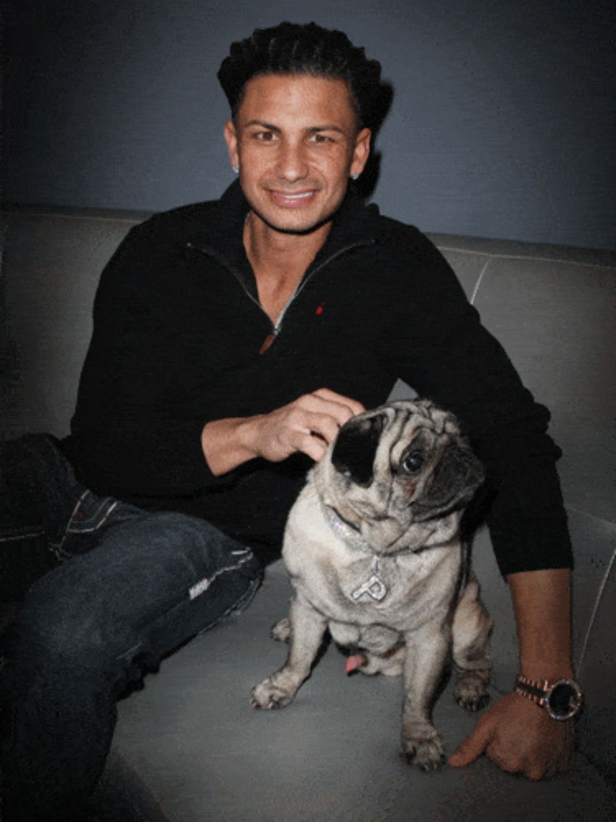 DJ Pauly D sitting on the couch beside his Pug