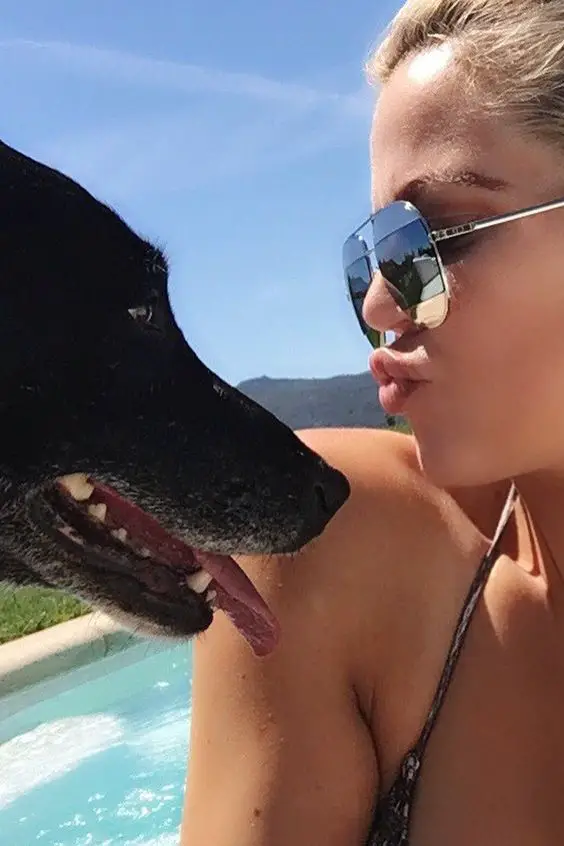 Khloe Kardashian pouting its lips towards her Labrador