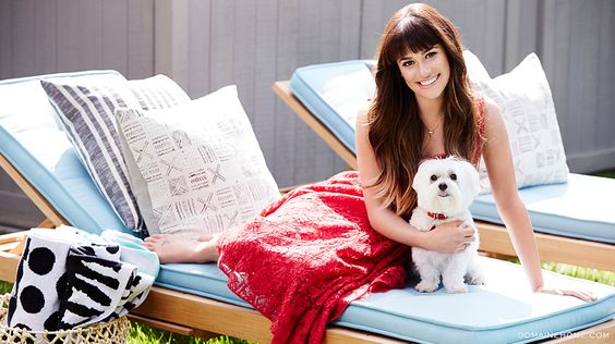 Lea Michele sitting on the beach bed with her Pomeranian mix dog
