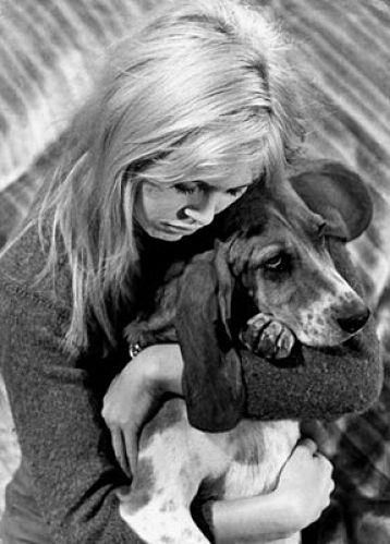 black and white photo of a Brigitte Bardot hugging a Basset Hound